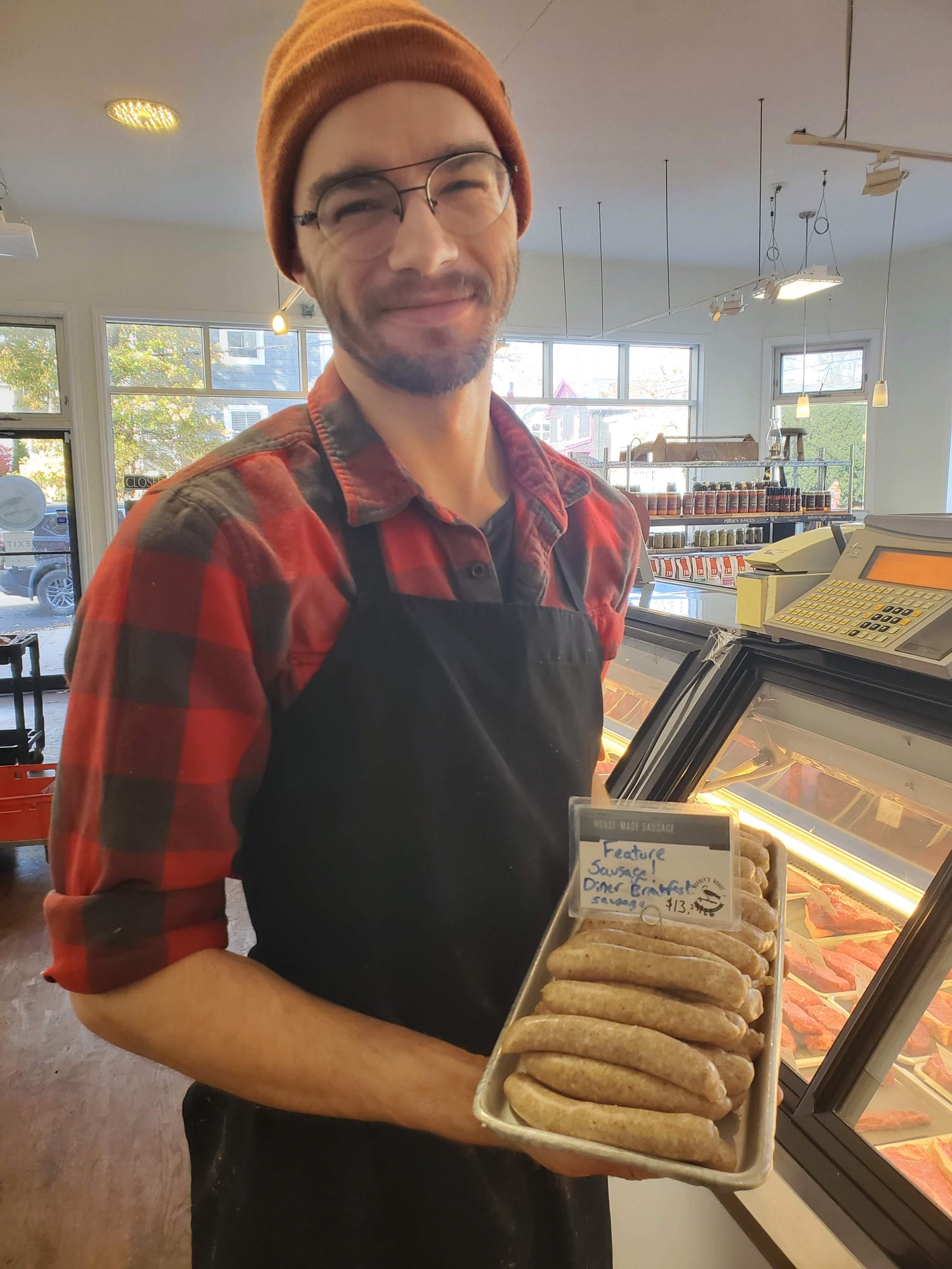 Osprey's Roost employee holding a tray of sausages